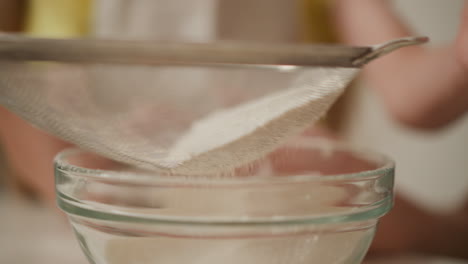 sifting flour into a bowl