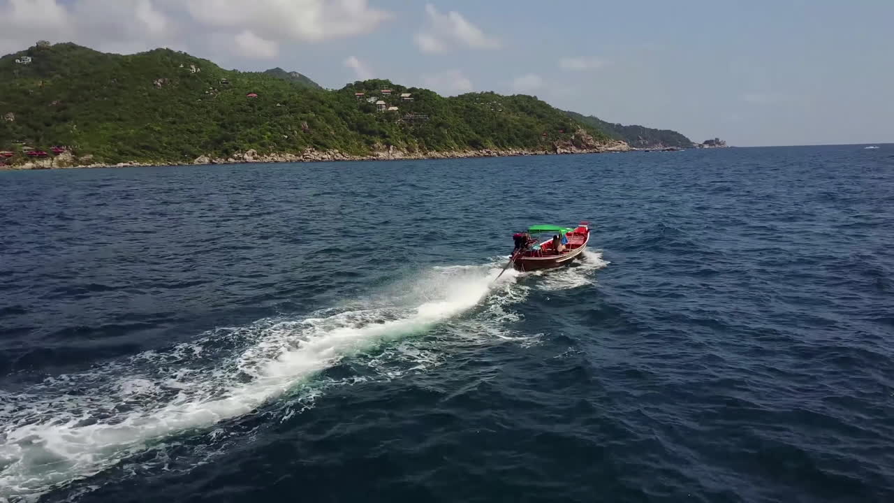 Drone flies over the longtail boat close to the coast. Koh Tao. Thailand