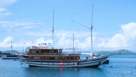 beautiful liveaboard ship boat moored in idyllic, calm ocean in fishing village of labuan bajo, flores island, nusa tenggara region of east indonesia