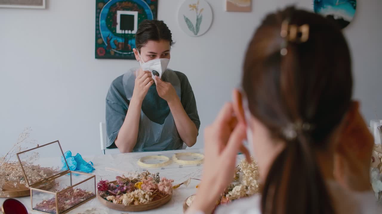 Women working together in a craft workshop, wearing masks and protective gear