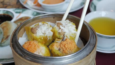 Using-chopsticks-for-eating-steamed-chinese-dim-sum-in-restaurant