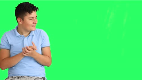 Teenage boy applauding at green screen background 1