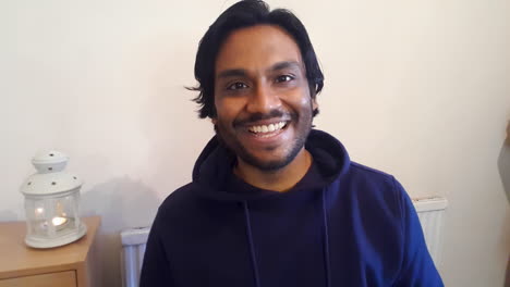 young man on joining video call waving and talking to friends directly to camera