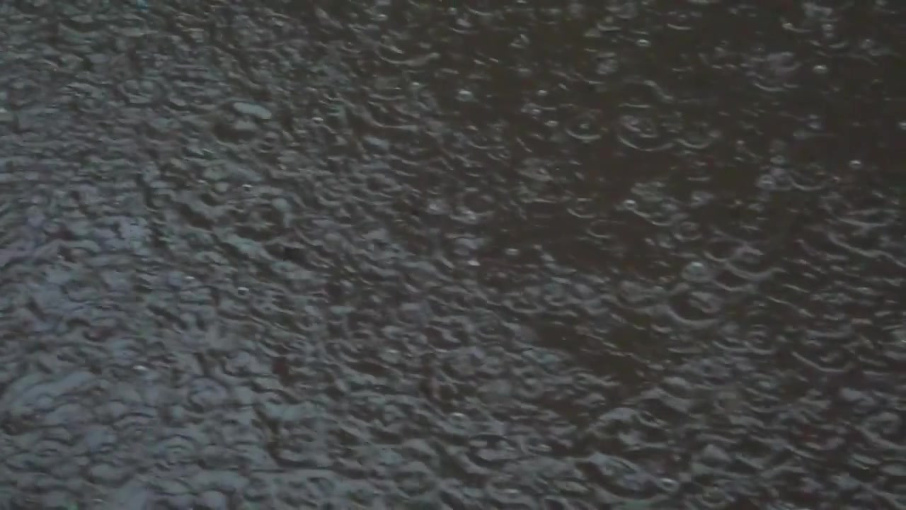 Rain in the city. Rain drops fall on the sidewalk.