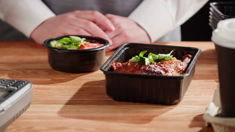 restaurant worker packing food containers