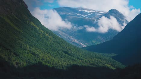 las nubes delgadas giran sobre el amplio valle montañoso cubierto de bosques.