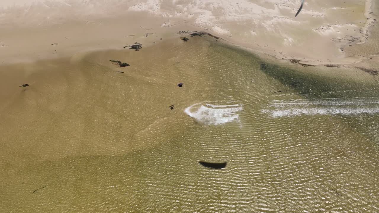 얕은 물에서 높은 공기 회전을 하는 수컷 카이트서퍼의 조감도