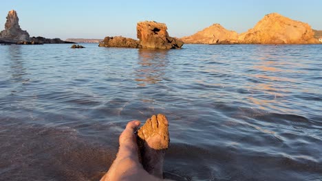 Relaxed-middle-aged-white-man’s-feet-by-the-beach-shore