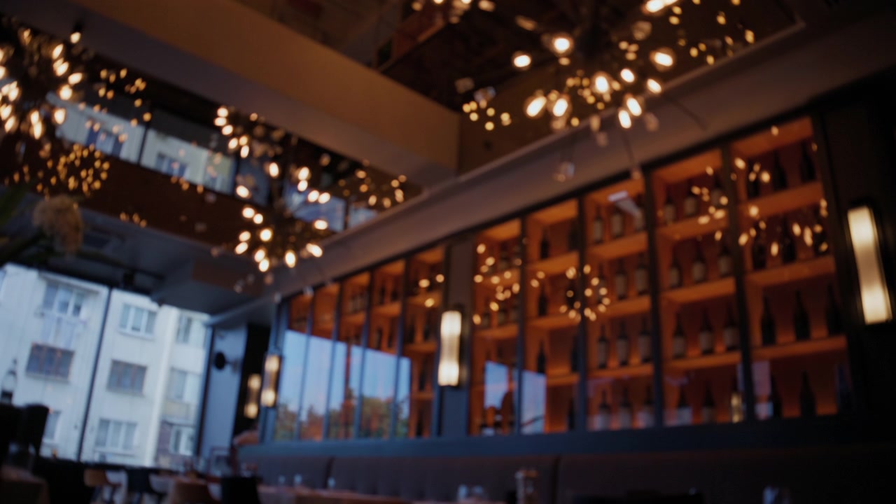 Eleganti plafoniere decorative creano caldi effetti bokeh luminosi all'interno di un ristorante moderno.