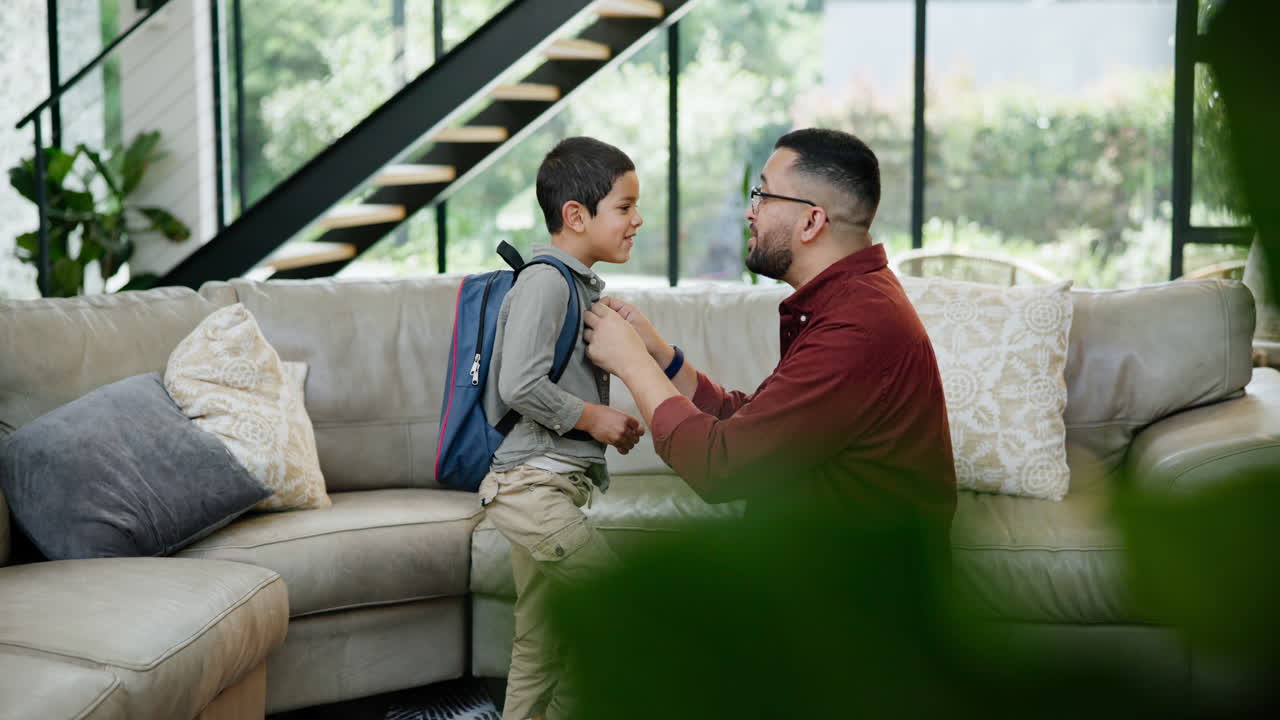 padre ayudando a su hijo a prepararse para la escuela