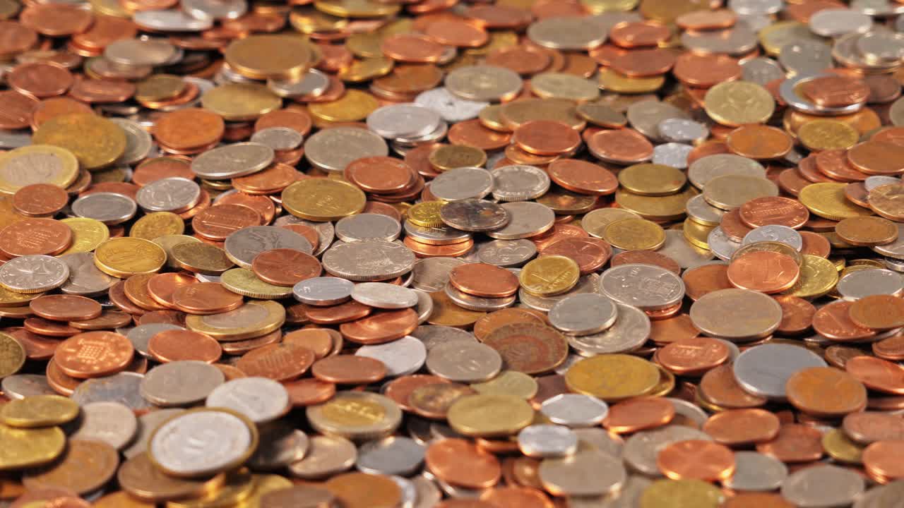 Coins scattered on a flat surface in various sizes and colors