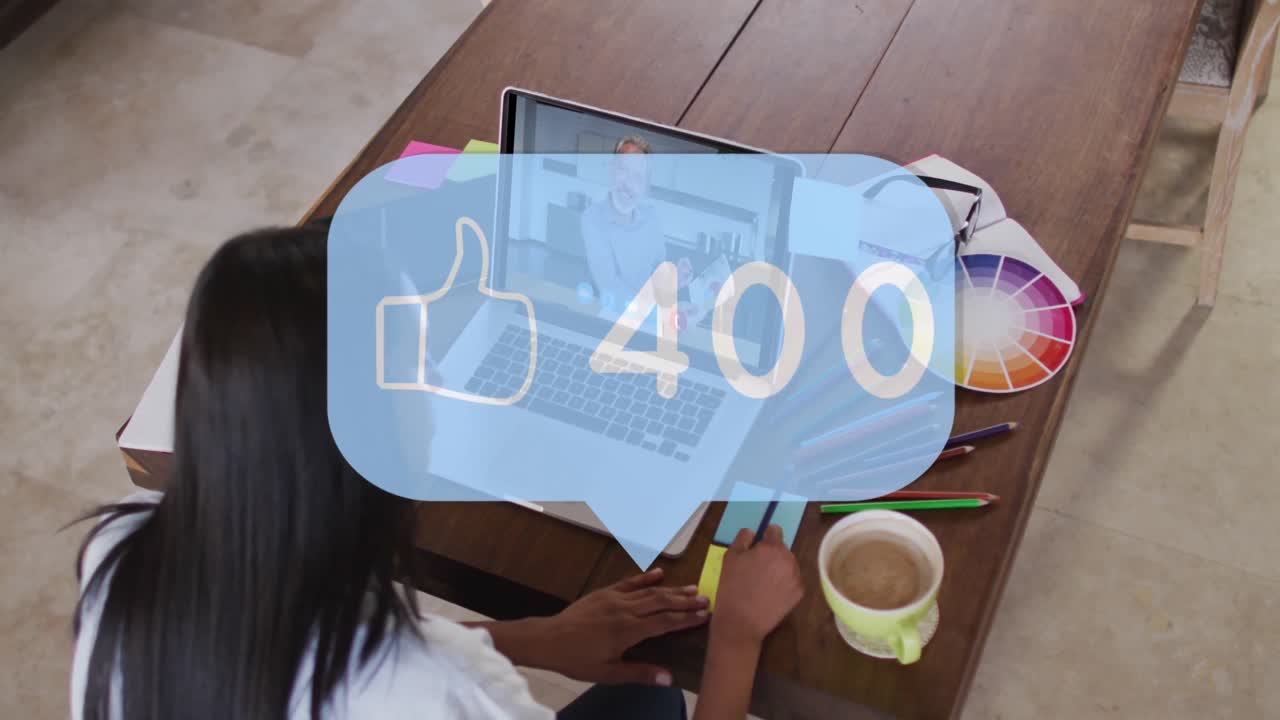 Animation of thumbs up icon and numbers over biracial businesswoman using laptop