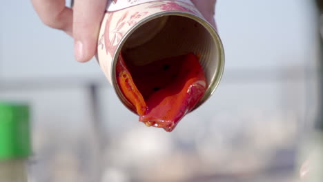 pouring oil and contents from a can