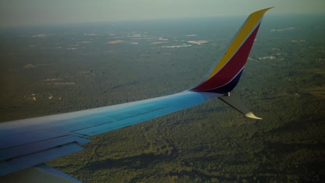 Konzentrieren-Sie-Sich-Auf-Die-Spitze-Eines-Flügels,-Der-Sich-über-Eine-Bewaldete-Landschaft-Dreht