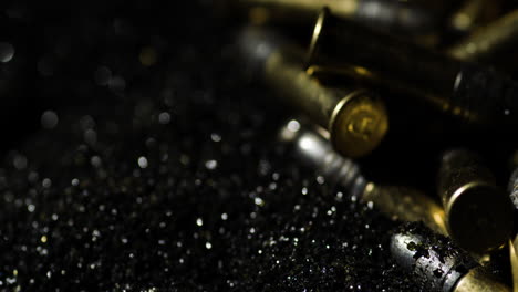 .22-Long-Rifle-bullets-on-gunpowder-pile,-close-up-macro-detail-shot,-circling