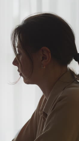 woman in profile view at a window