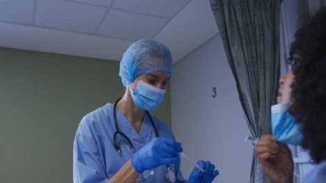 una doctora caucásica con máscara facial dando una prueba de esponja de covid a una paciente