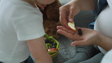 video de mano de la madre convenciendo al bebé para que coma fruta.