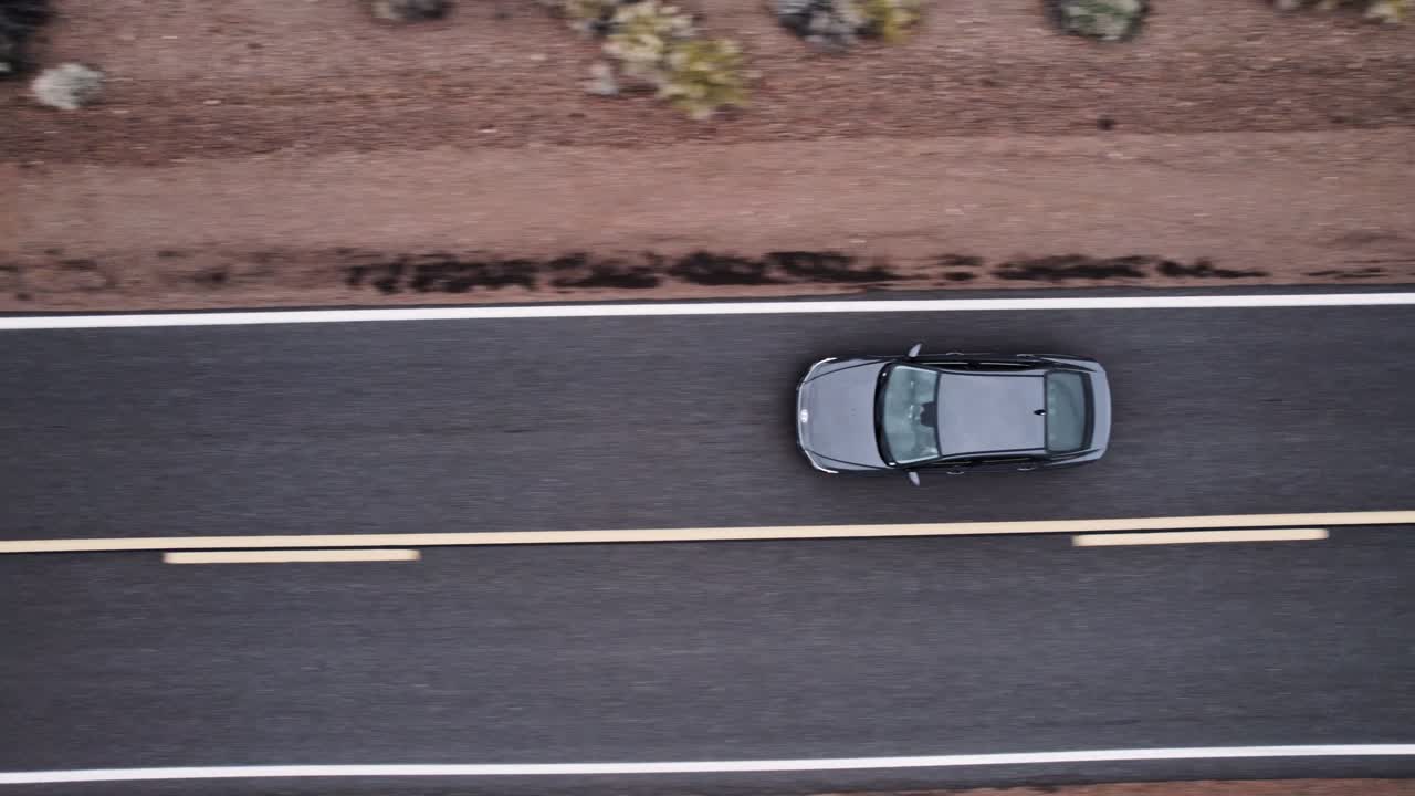 Aerial Drone Shot of a Car Driving on a Long Isolated Road in the Desert
