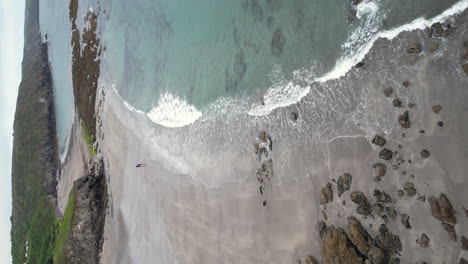 un video vertical de kennack sands en cornualles, inglaterra, que muestra la playa y el promontorio rocoso