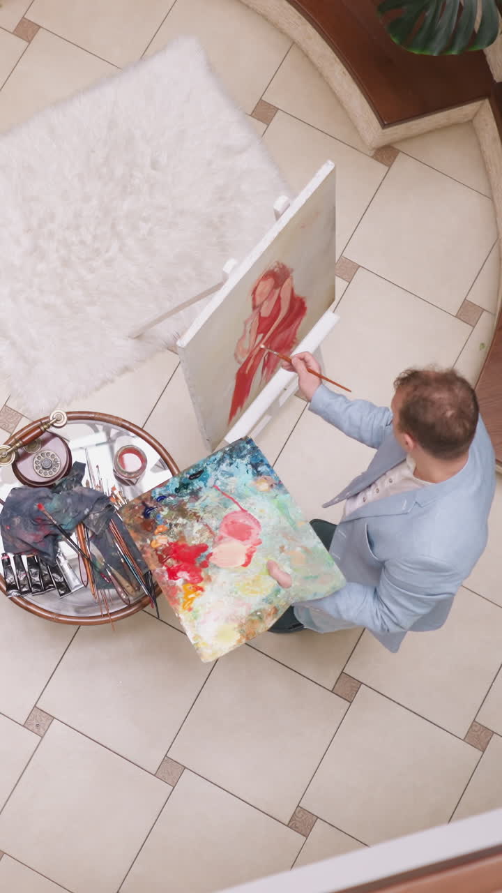 el artista dibuja a una mujer bonita posando entre plantas de interior. el retratista trabaja con amor sobre la imagen de una mujer elegante en la galería. el hombre crea un producto de arte