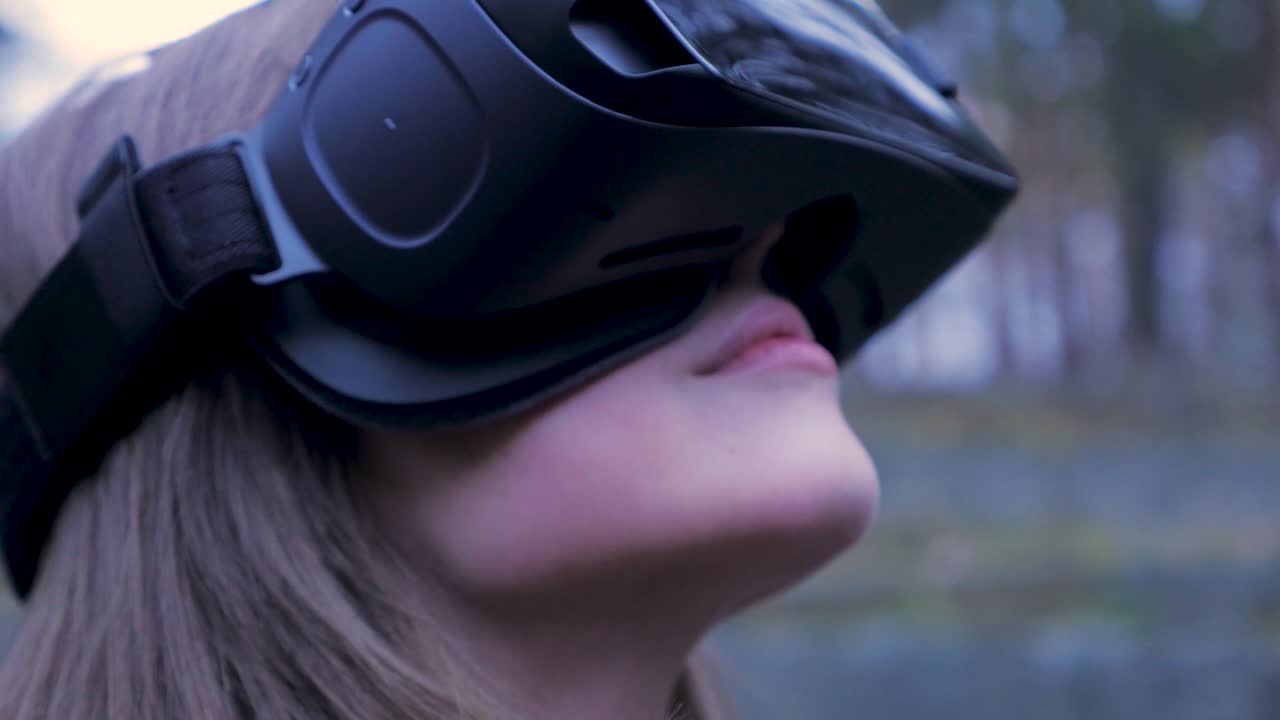 야외에서 vr 헤드을 착용하는 소녀