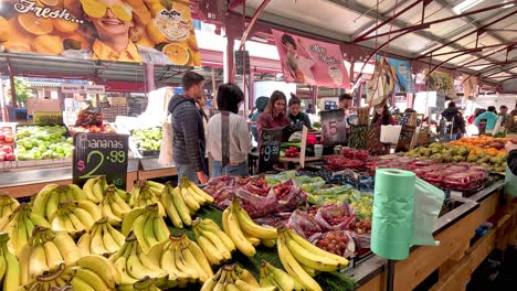 compradores en un vibrante mercado de frutas y verduras