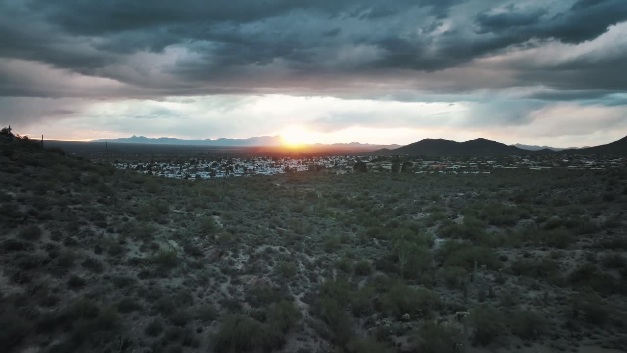 sabana a través del desierto de sonora con la ciudad de tucson durante la puesta de sol al fondo en el condado de pima, arizona