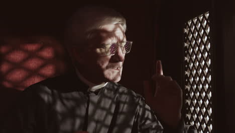senior pastor sitting in confessional