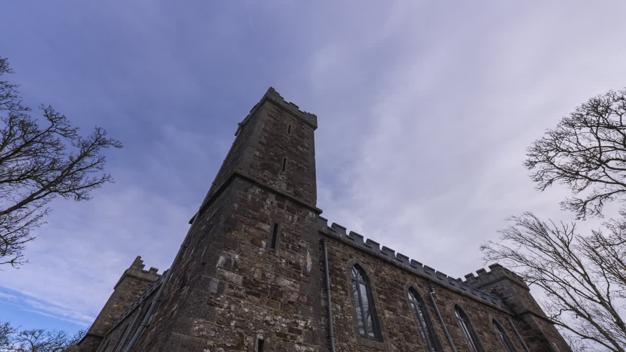 Timelapse di un castello storico locale circondato da alberi, visto da terra in un giorno di inizio primavera soleggiato e nuvoloso nella contea di Roscommon in Irlanda.
