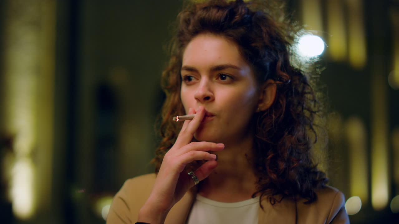 야외 에서 담배 를 피우는 사려 깊은 여자