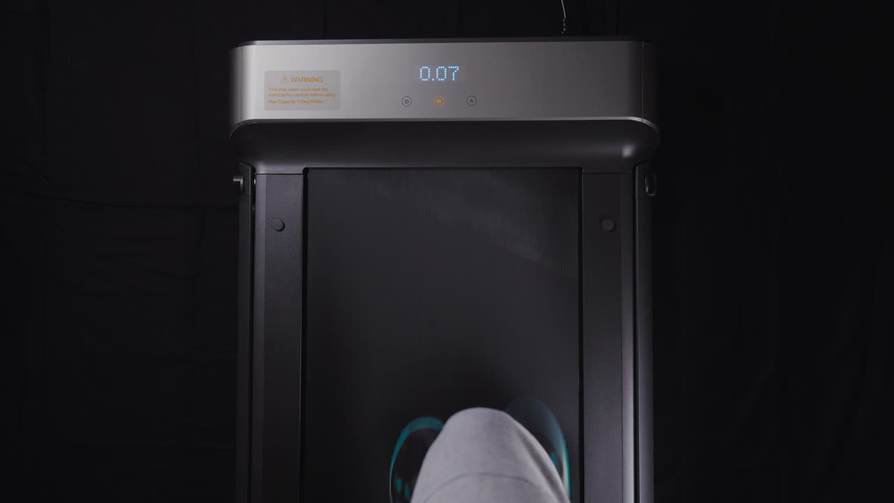 Point of view shot of a man's feet walking on a treadmill