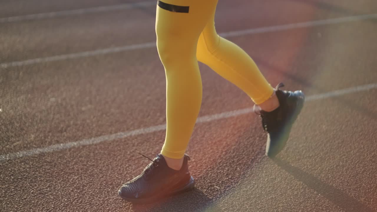 노란색 스포츠 의류 를 입고 야외 트랙 에서 달리는 여자