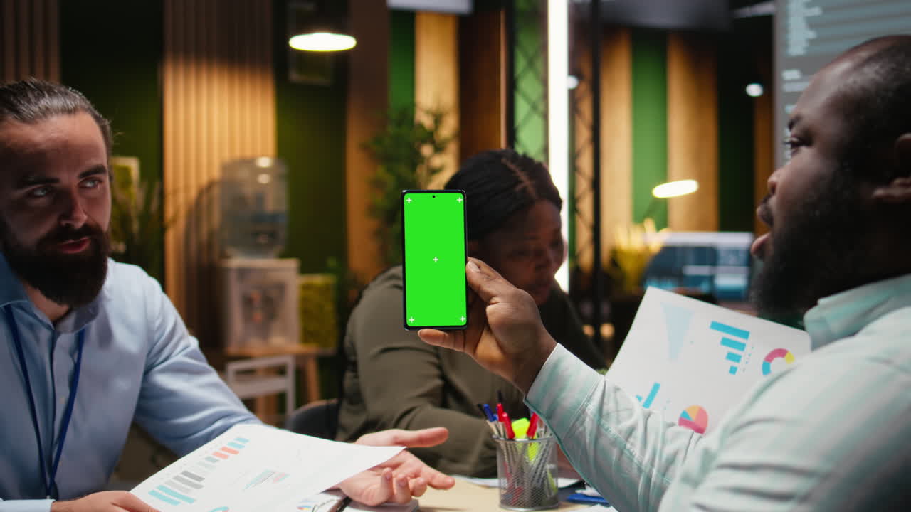 Diverse company workers hold phone with isolated chroma key