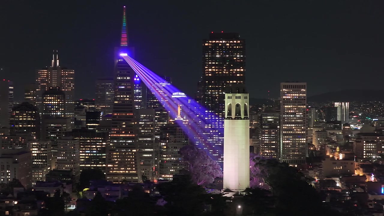 Riprese con drone del centro di San Francisco, installazione artistica con fasci di luce tra la Coit Tower e il Transamerica Pyramid.