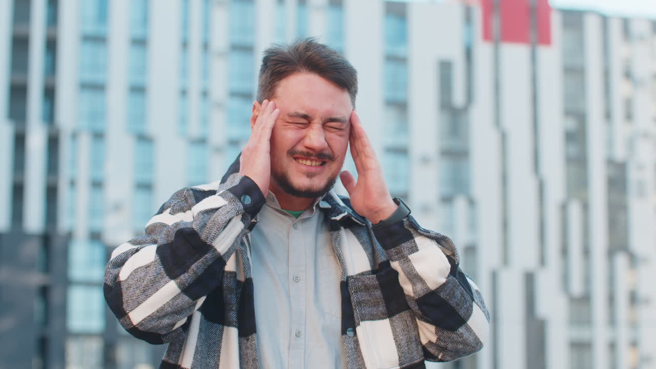 성숙 한 백인 사업가 는 도시 거리 에 있는 건물 에 맞대고 서 있을 때 두통 을 느다