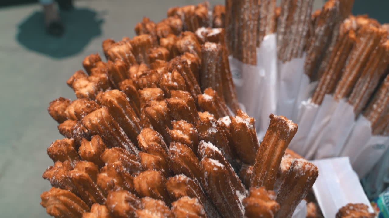 Primo piano di deliziosi churros, dorati e croccanti, cosparsi di zucchero, che simboleggiano le delizie culinarie messicane