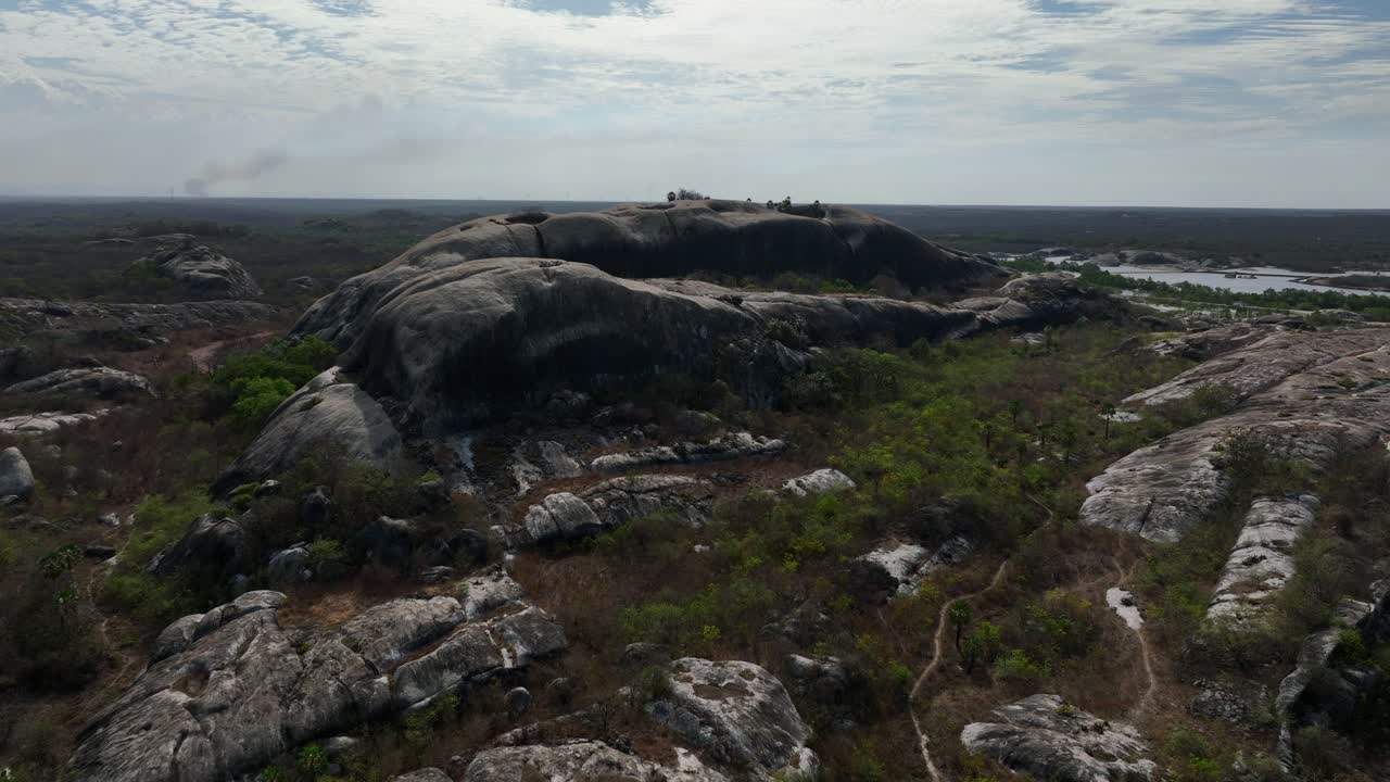 Rocky terrain in Chaval, Ceara, with lush greenery and distant hills visible