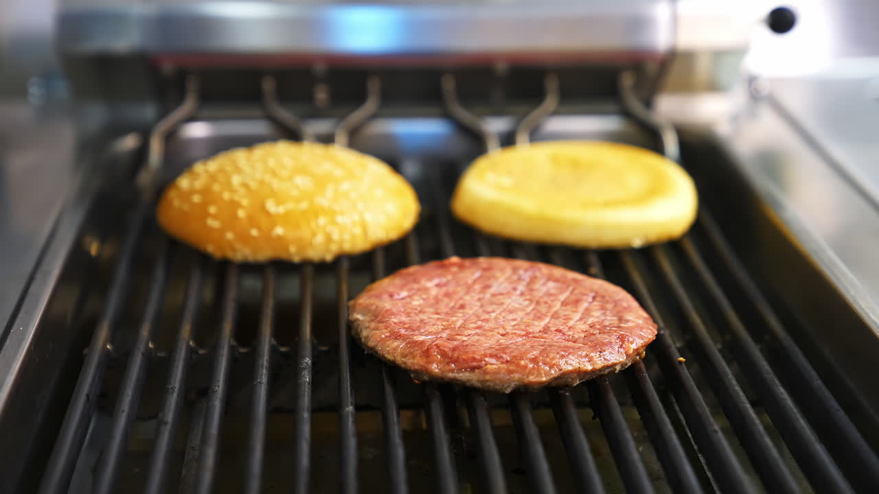 Frying meat and burgers on stove. Preparing burger and beef for hamburger. Cooking hamburger on hot grill pan in fast food restaurant. Close-up.