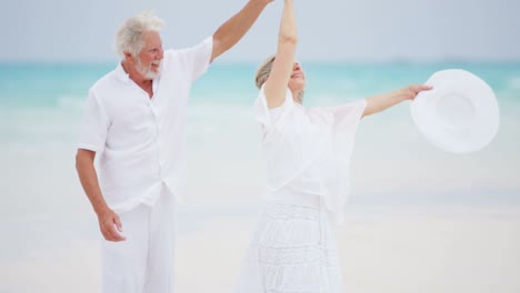 una pareja caucásica jubilada caminando por una playa del caribe.
