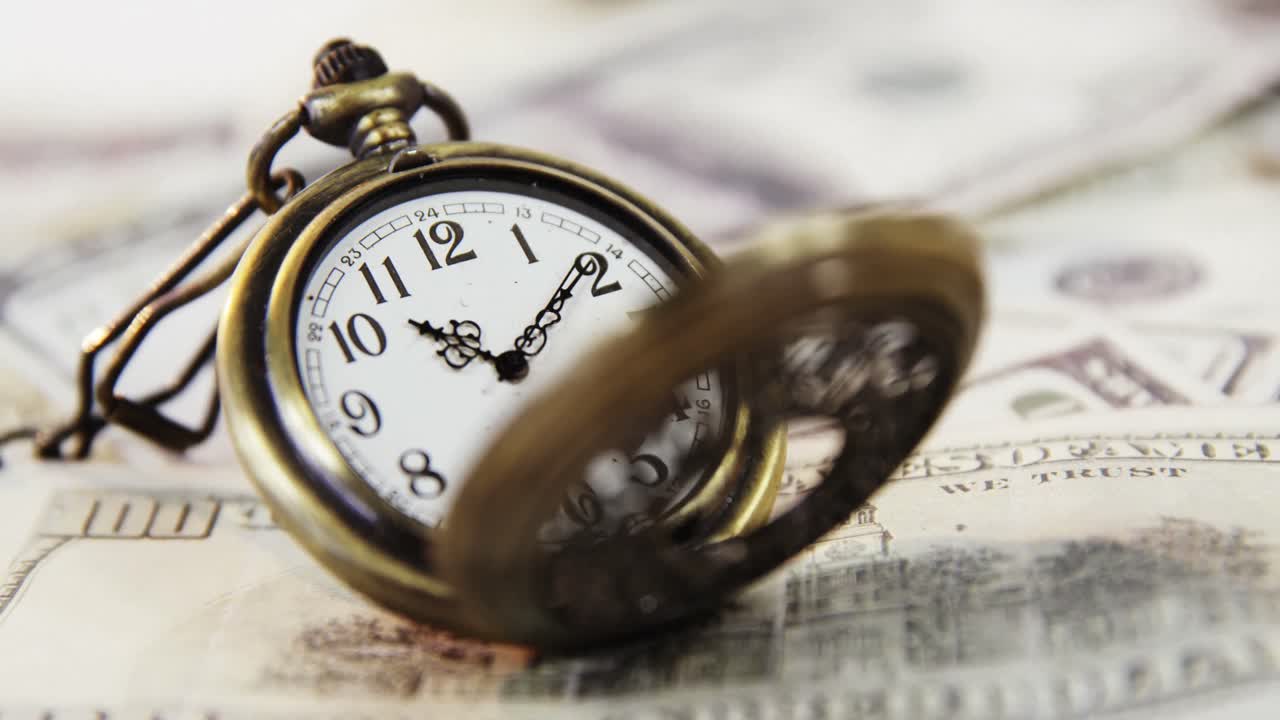 Primer plano de un reloj de bolsillo sobre un euro y un dólar