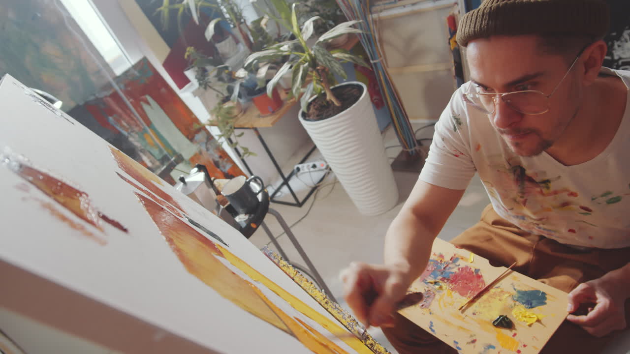 artista talentoso que usa un cuchillo de paleta para pintar en lienzo