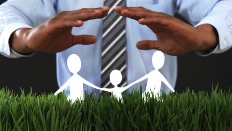 Businessman-with-cutout-paper-chain-family-with-the-protection-of-hands