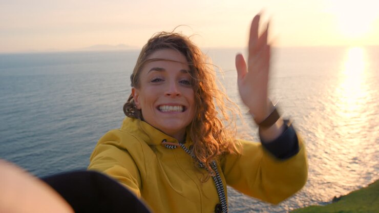 Donna che si fa un selfie al tramonto sull'oceano