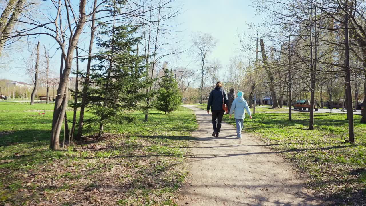 Güneşli Bir Parkta Toprak Yolda Yürüyen İki Kişi