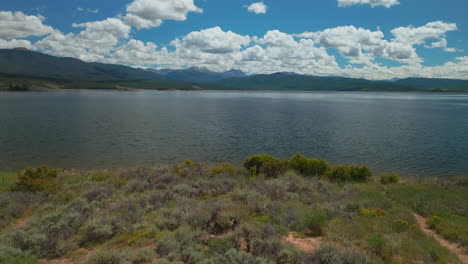 aerial cinematic drone high altitude shore of grand lake shadow mountain grandby colorado rocky mountain national park entrance calm clear beautiful summer morning boating islands forward motion