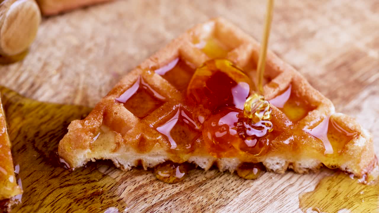 watering soft waffles with bee honey during dessert cooking