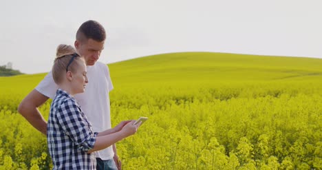 farmers discussing while using tablet computer at farm 13