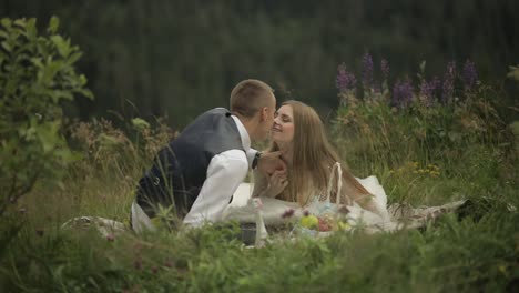 Groom-with-bride-having-a-picnic-on-a-mountain-hills.-Wedding-couple.-Family