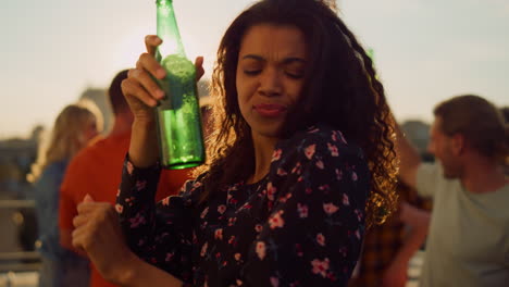 una mujer afro disfrutando de una fiesta con cerveza al aire libre. una chica africana bailando en una fiesta.